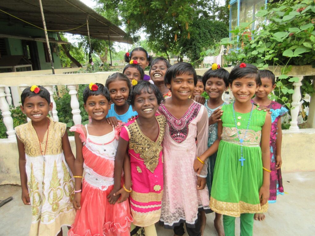 Children from Nambikkai Illam smiling in a group